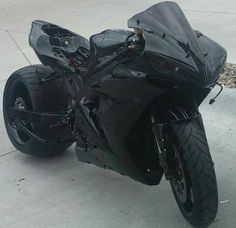 a black motorcycle parked on top of a sidewalk