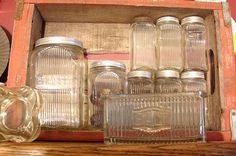 an old wooden box with glass jars in it