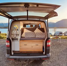 the back end of a van with pillows in it's trunk and seats folded down