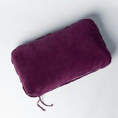 a purple pillow sitting on top of a white table