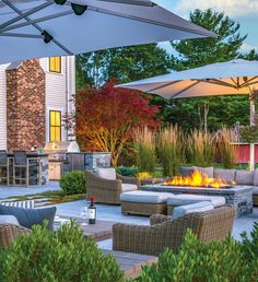 an outdoor fire pit surrounded by wicker furniture