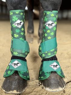 the legs and feet of a horse wearing green shamrocks on it's boots