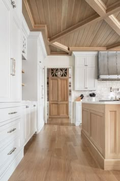 an empty kitchen with white cabinets and wood flooring on the walls is pictured in this image