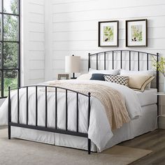 a bedroom with white walls and wood floors