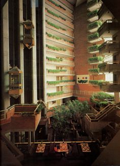 an apartment building with many plants growing in the balconies and on the second floor