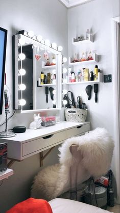 a bedroom with a vanity, mirror and lights