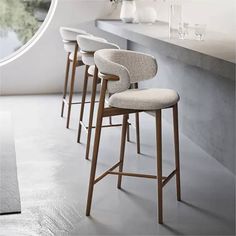 three bar stools sitting in front of a counter