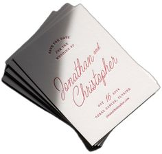 three folded cards with the names of two people and one is in red ink on white paper