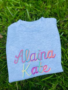 "Our girls embroidered sweatshirt makes the perfect outfit! It's professionally embroidered in pastel rainbow letters and is personalized and customized. Our girls monogram sweatshirt is available in toddler and youth sizes. HOW TO ORDER: 1) From the first dropdown menu, select sweatshirt size 2) From the second dropdown menu, select sweatshirt color 2) In the personalization box, please enter name (note: all letters are lowercase) 3) Click \"Add to Cart\"" Embroidered Name Shirt, Pink Cotton Sweatshirt With Letter Embroidery, Multicolor Crew Neck T-shirt With Name Print, Spring Pink T-shirt With Custom Embroidery, Rainbow Cotton Crew Neck Sweatshirt, Kids Embroidered Sweatshirt, Monogram Sweatshirt, Personalized Birthday Shirts, Girls Applique