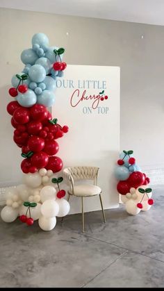 the balloon arch is decorated with blue, red and white balloons that spell out our little cherry on top