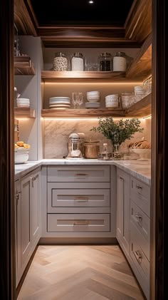 a kitchen with white cabinets and wooden shelves filled with dishes on top of each shelf