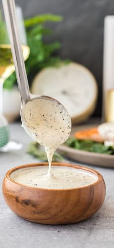 a wooden bowl filled with cream sauce on top of a table