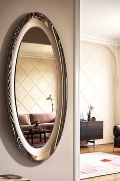 an oval mirror hanging on the wall in a living room