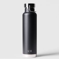 a black stainless steel water bottle with the k m logo on it