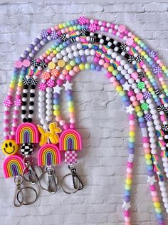 a bunch of beads are hanging on a wall with some keychains attached to it