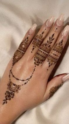 a woman's hand with henna tattoos on it