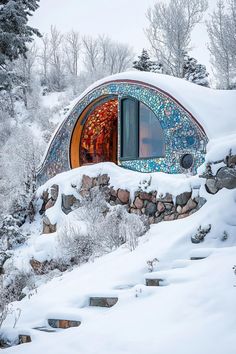 an unusual house built into the side of a snowy mountain