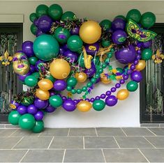 a bunch of balloons that are in the shape of a butterfly on a wall with mardi gras decorations