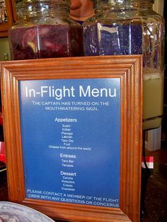 there is a sign that says in - flight menu on the table next to some jars