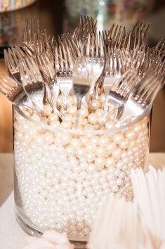 a plastic container filled with forks and pearls