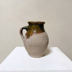 a white and brown vase sitting on top of a table