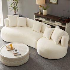 a large white couch sitting on top of a carpeted floor next to a table