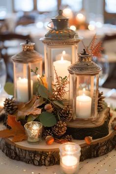 two lit candles are on top of a wooden slice with pine cones and greenery