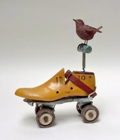 a yellow shoe is sitting on top of a toy roller coaster with a bird perched on it