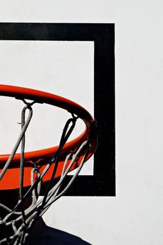 an orange and black basketball going through the rim of a hoop with white lines on it