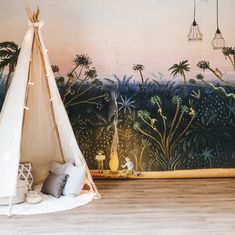 a teepee tent sitting on top of a wooden floor next to a wall mural