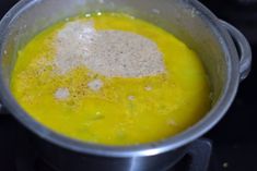 a pot filled with yellow liquid on top of a stove