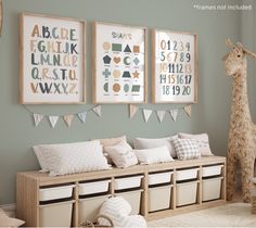 a baby's room with posters and toys on the wall, including a stuffed giraffe