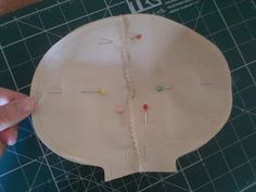 someone is making a paper doll head with pins and needles on the top of it