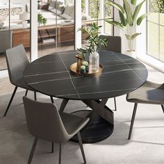 a dining table with chairs around it in front of a living room window and potted plant