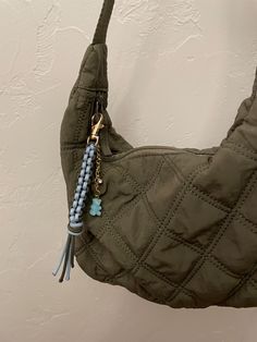 a handbag hanging on the wall with a tassel attached to it's handle