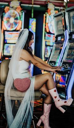 a woman sitting on top of a chair next to a slot machine