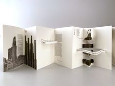 an open book with black and white cityscape on the front, inside and out