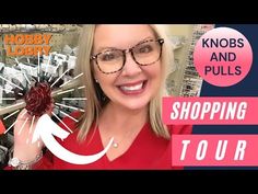 a woman holding up a piece of fruit in front of a store sign with the words hobby