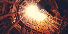 looking up at the inside of a circular building with windows and light coming from it