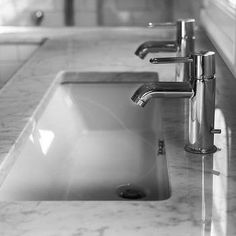 a bathroom sink with two faucets on the counter top and one is empty