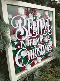 a christmas sign hanging from the side of a tree