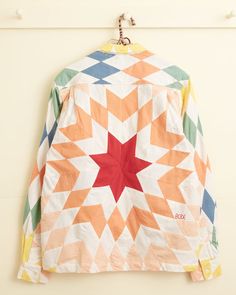 an orange, white and green jacket hanging on a hook with a star design on it