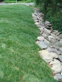 there is a rock wall in the grass