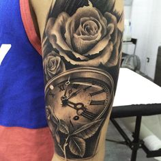 a man with a clock and rose tattoo on his arm