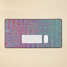 a computer mouse and keyboard sitting on top of a wooden surface with colorful designs around it