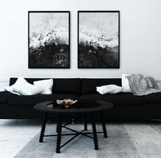 two black and white paintings hang on the wall above a couch in a living room