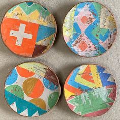 four colorful painted plates sitting on top of a wall