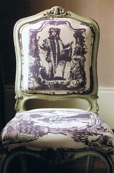 an old chair with a blue and white design on it