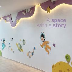 the wall has many cartoon pictures on it and is decorated with lights, stars, and letters