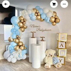 a baby shower with balloons, teddy bear and other items in front of the wall